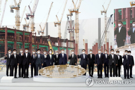 지난달 13일 문재인 대통령이 경기 평택시 삼성전자 평택단지 3라인 건설현장에 마련된 야외무대에서 열린 'K-반도체 전략 보고'에서 '반도체 생태계 강화 연대 협력 협약식'을 마친 후 참석자들과 기념촬영을 하고 있다. 연합뉴스